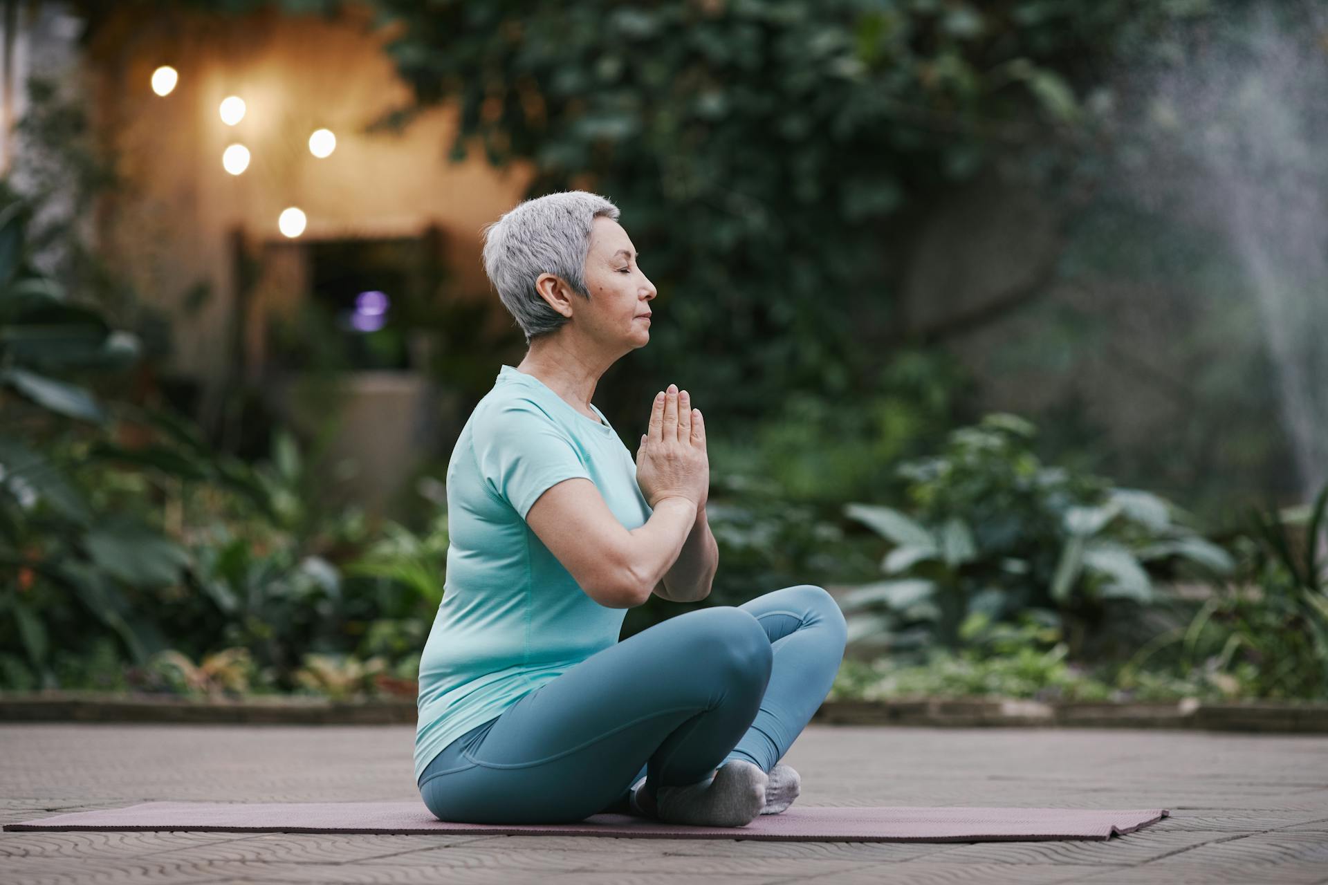 a picture of a woman meditating on a yoga mat